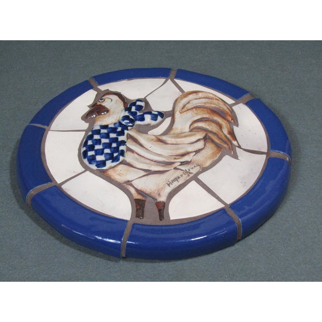 Hand-crafted rooster wall plaque by Hogan Young. The relief-modeled bird—checkered scarf and all—sits within a mosaic...
