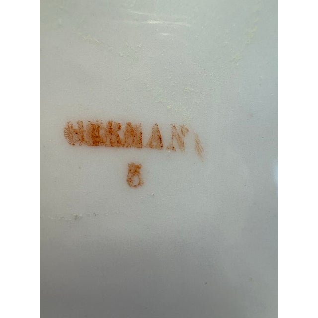 A charming turn-of-the-century German porcelain cabinet plate featuring a richly shaded cherry motif framed by a soft...