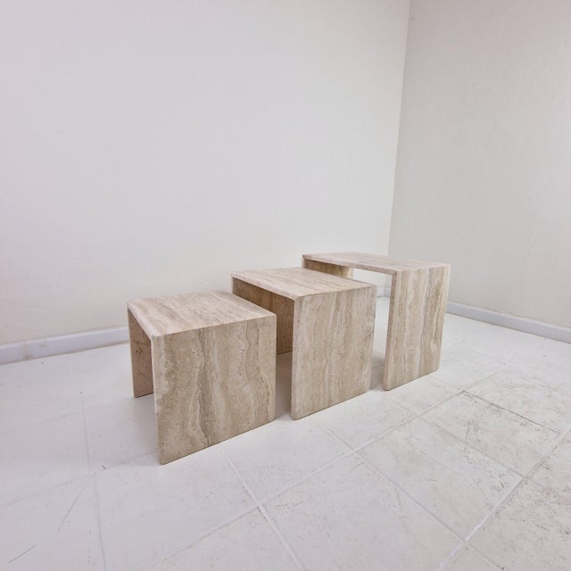 Elegant set of three nesting tables in grooved travertine, made in italy in the 1980s. these sculptural side tables...