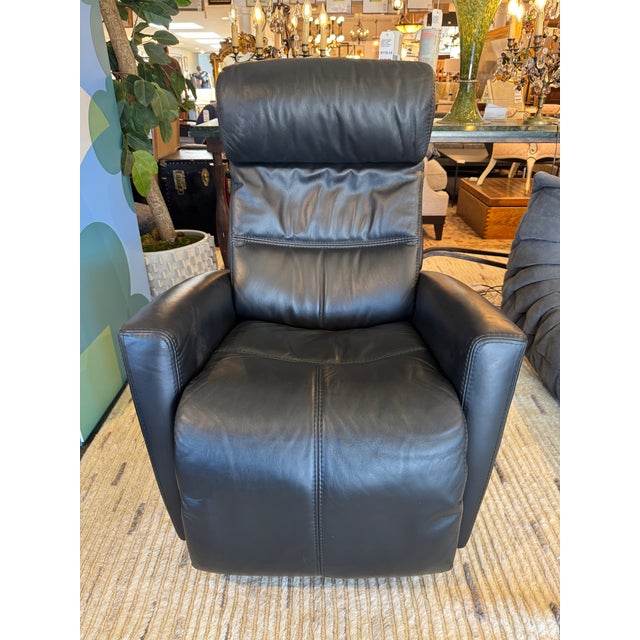 Design Plus Gallery presents a Power Swivel Recliner from Fjords. This black leather recliner has padded arms, a channel-...