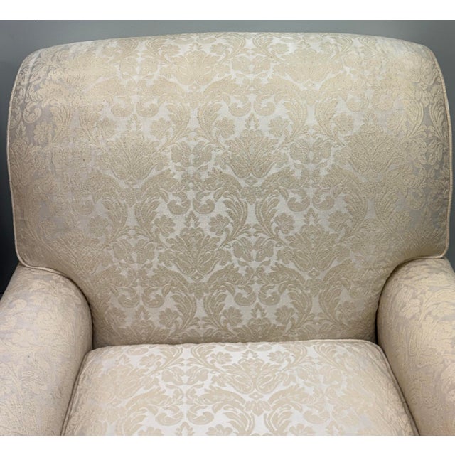 Elegant matching pair of generously proportioned armchairs upholstered in a soft cream damask fabric. Each chair features...