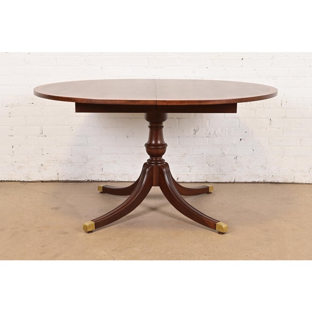 An exceptional Georgian or Regency style pedestal extension dining table In the manner of Baker Furniture USA, Circa 1980s...