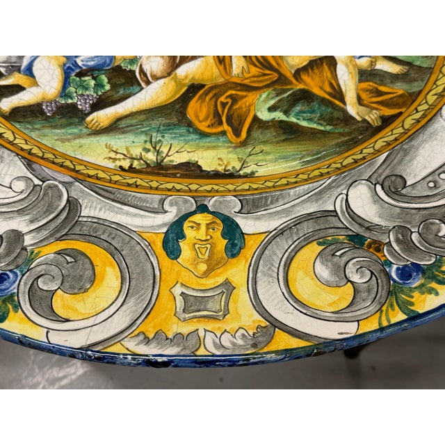 A massive tin glazed earthenware platter from the Deruta region of Italy. The plater depicts a bacchanalian scene and...
