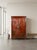 The exterior is finished with a distressed, aged crimson red lacquer. The front panels and outer borders are heavily...