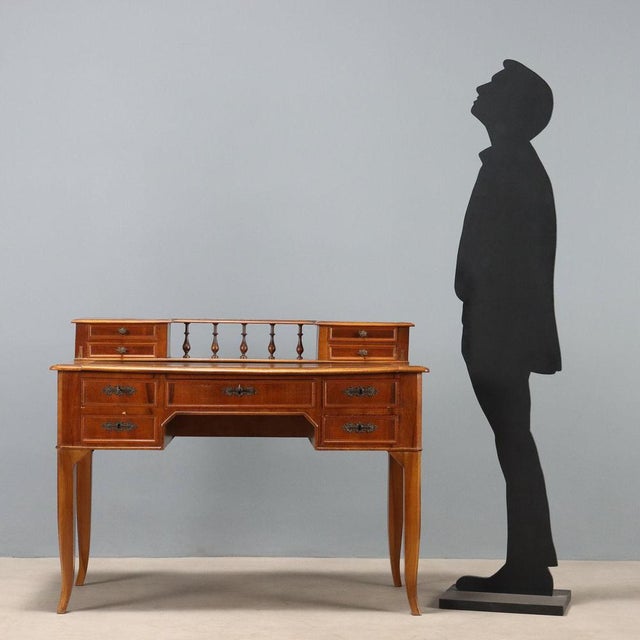 Umbertina walnut desk. Top with black leather insert and backsplash with side drawers and a central balustrade. Five...