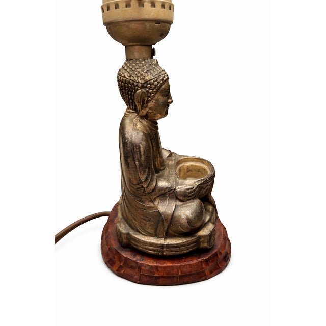 This early mid-century table lamp features a serene seated Buddha figure, Made in Japan, cast in metal with a warm,...