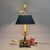 A classic Chapman desk bouillotte-style lamp dated 1984, crafted in warm antiqued brass with a tailored black tole shade...