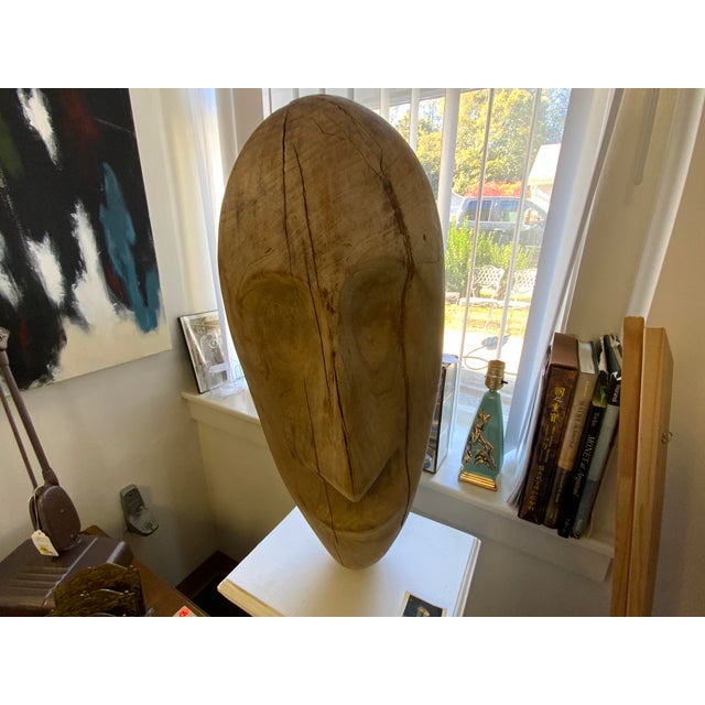 20th century sculpture on column stand by artist Nick Santoro. Carved wood figure, raw wood. Mounted to stand, wood...
