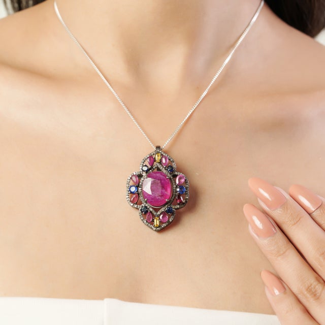 This elegant 925 sterling silver pendant showcases a refined, symmetrical design centered around a vibrant glass filled-...