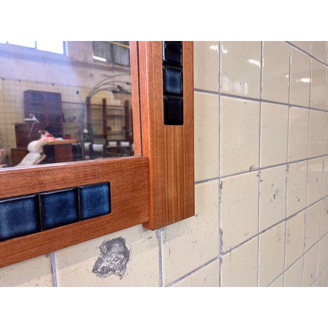 This large Danish mirror features a warm teak frame beautifully inlaid with handcrafted blue tiles, creating a refined and...