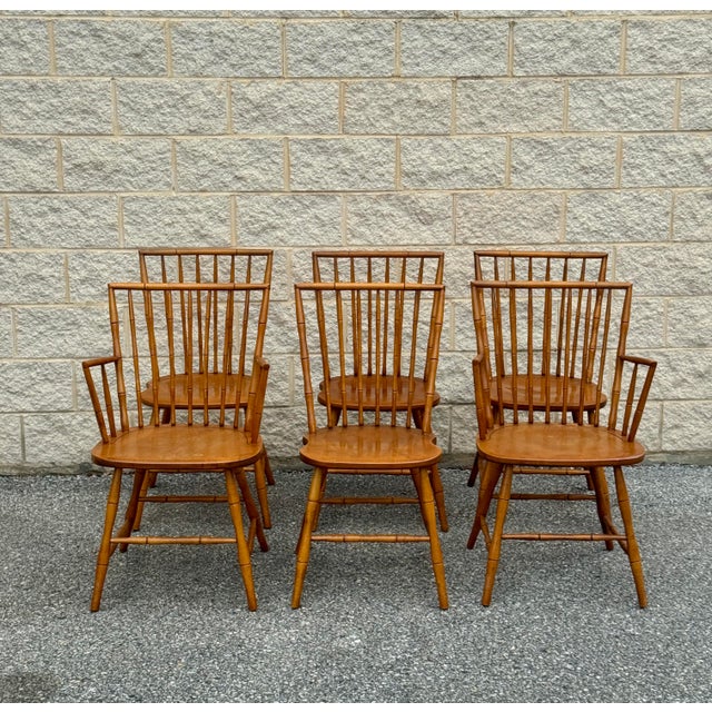 A set of six vintage Windsor-style dining chairs, including four side chairs and two armchairs. Crafted from solid wood,...