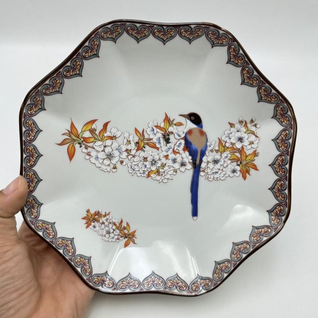 A set of four Japanese porcelain plates featuring . The rims are decorated with a continuous painted border of heart-...