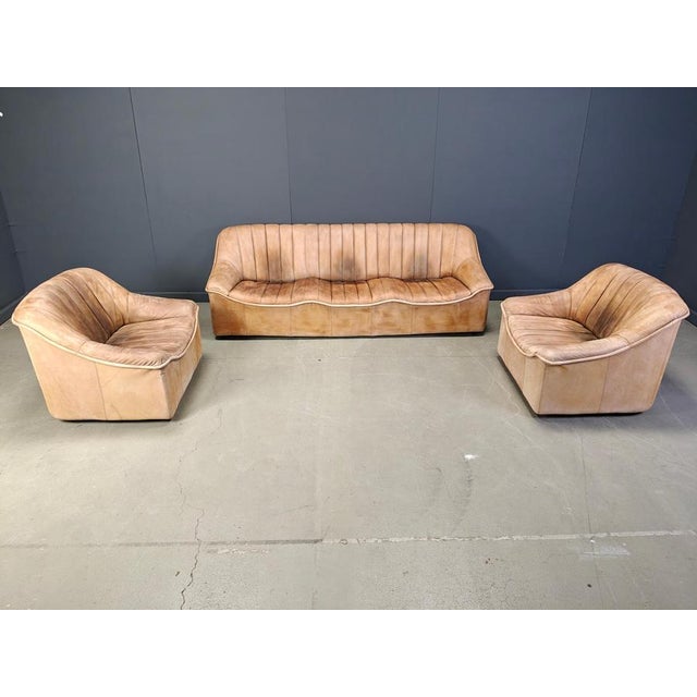 Beautiful mid century leather sofa set consisting of a three seater and two armchairs. Gorgeouis colour with the right...