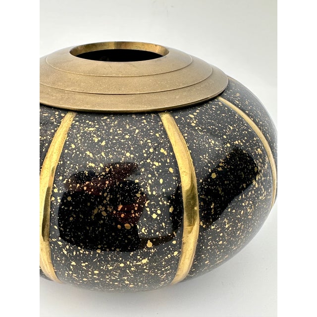 This 1980's-era vase features a squat form with a two-toned black & golden brass finish. A fine vessel for dry floral...