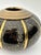 This 1980's-era vase features a squat form with a two-toned black & golden brass finish. A fine vessel for dry floral...