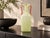 An exceptional vintage glass amphora made of delicate green speckled art glass with two artfully attached, coral-red...
