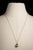 An elegant 12mm Tahitian pearl pendant with three round, faceted diamonds in 18K gold at the bottom and an 18K gold end...