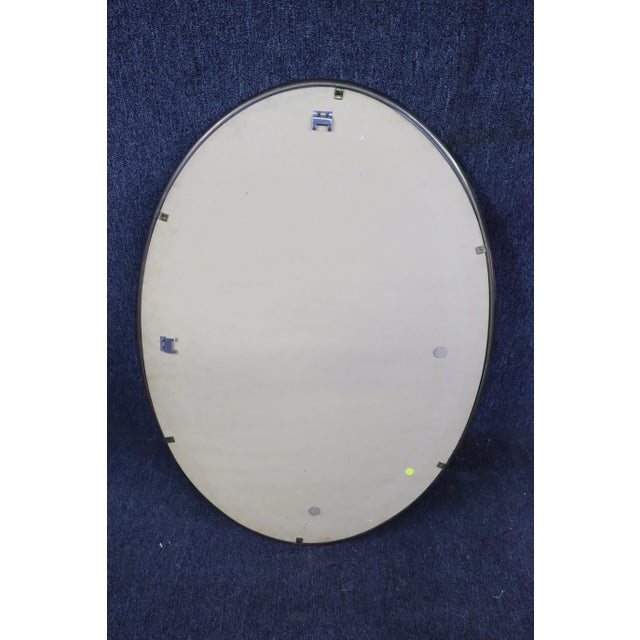 Mid Century oval mirror in brass frame with tinted glass