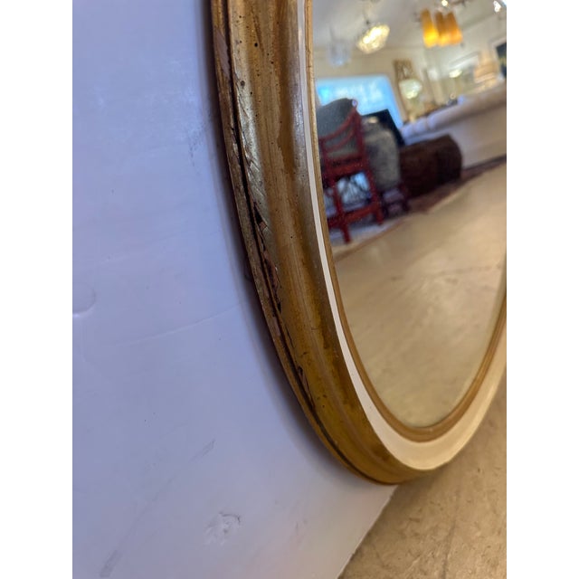 Pretty oval cream painted and gold leaf vintage wall mirror.