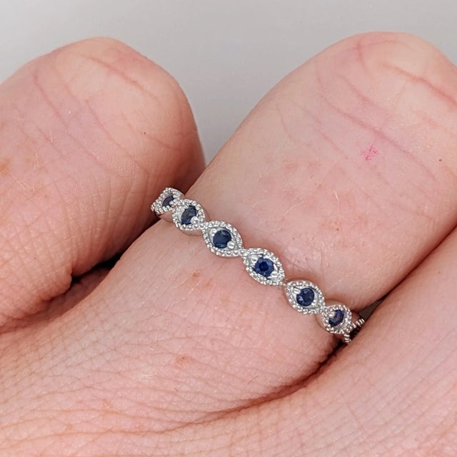 This eternity band ring in solid 14K gold features blue sapphires with milgrain details extended all the way around the...