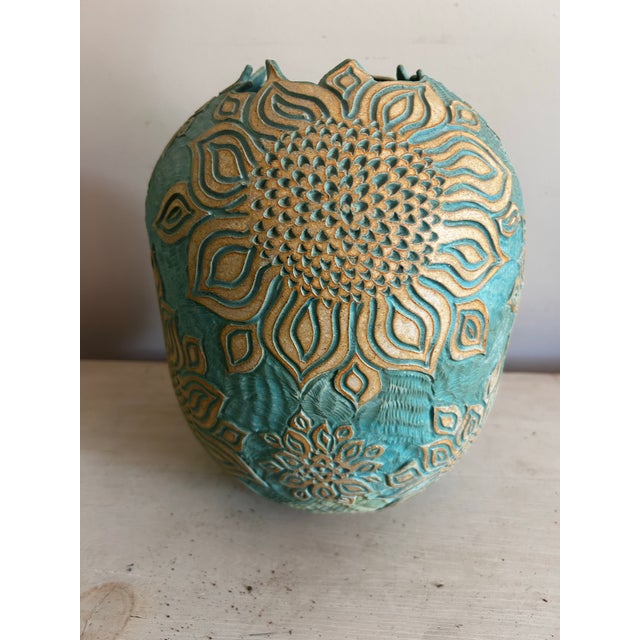 Beautiful large, vintage, studio pottery vase in blue with a hand etched sunflower relief pattern. Illegible signature on...