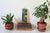 Vintage hand painted folk art wood carving features a textured impasto street scene of colonial architecture in rich teal,...