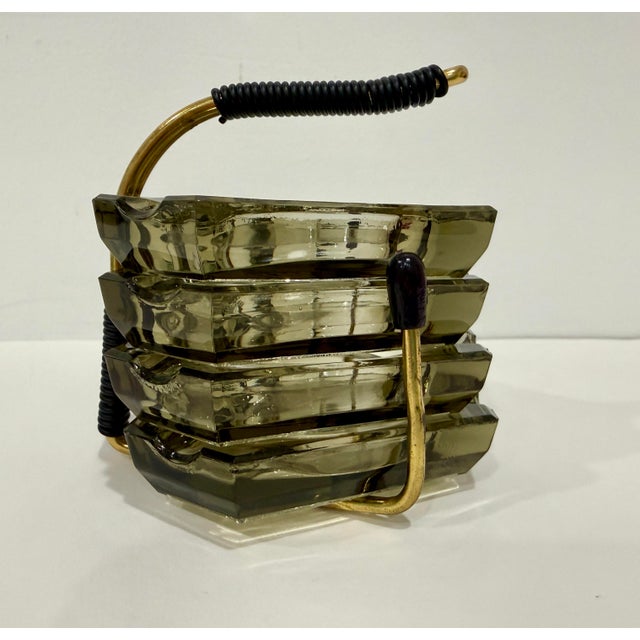 MCM 1950s stacking party set ashtrays in smoky gray glass. Includes four hexagonal ashtrays, and one metal carrying stand....