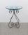 A round metal, brass, and glass side table, circa late-20th century. Table has a substantial round glass top supported by...