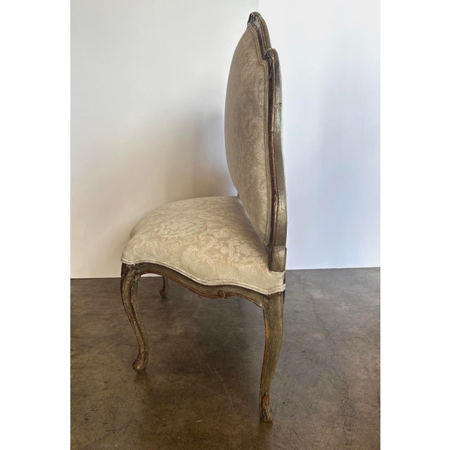 Charming, hand-carved, hand-painted and gilded bench. Floral detail. Newly upholstered with covered, double corded trim.