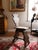 Primitive hand-carved wood chair with a scroll-cut silhouette back and a plank seat, raised on shaped, splayed trestle...