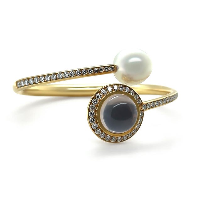A striking Paspaley Muse Signature bangle crafted in 18ct yellow gold, featuring a luminous Australian South Sea pearl...