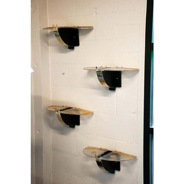 Italian Mazzega wall sconces with black and brass bases and amber Murano glass panels. Glass shines up from center of...