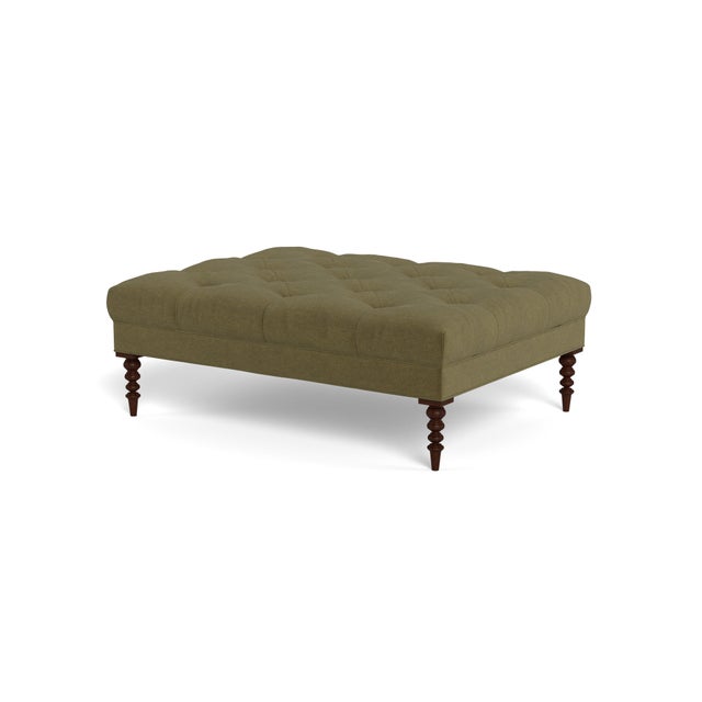 A large cocktail ottoman, with beautiful tufting set atop a trim upholstered box, with wonderfully turned legs. Legs...