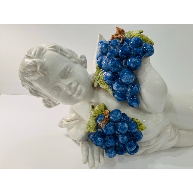 This finely crafted ceramic putti is from Italy It features bunches of grapes as accents The condition is excellent