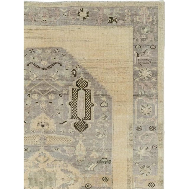 This mid-20th-century Turkish Anatolian accent rug presents an elongated central medallion set against a pale ivory and...