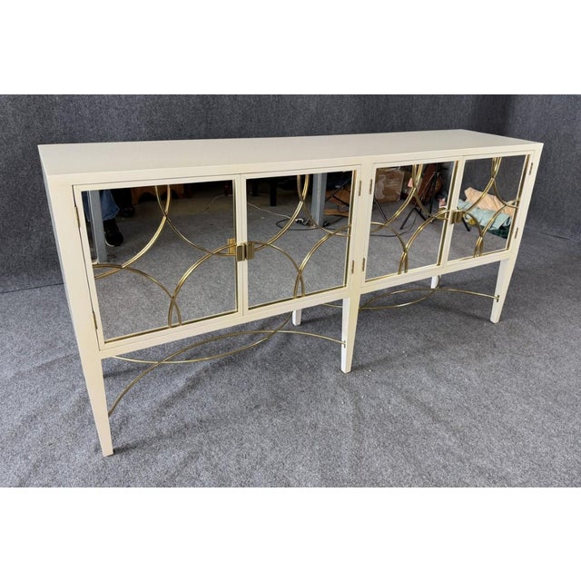 This Alden Parkes Designs White Lacquer Mirror Door Sideboard features a sleek lacquered finish with mirrored doors...