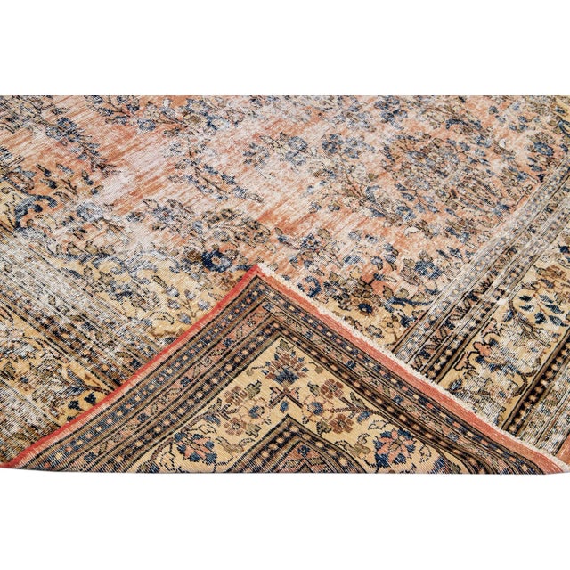 Beautiful Vintage Persian distressed hand-knotted wool rug with a peach color field. This Persian rug has a beige frame...