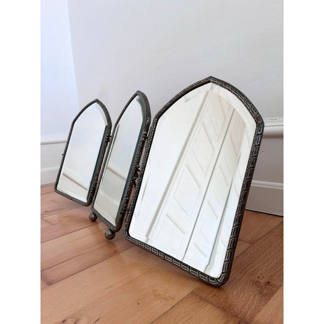 Art Deco tri-fold vanity mirror, English, from the 1920s. This tabletop boudoir mirror features three pointed-arch panels...