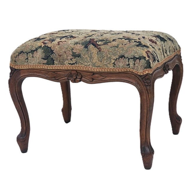 Elegant antique French walnut footstool or ottoman dating to the early 1910s. This charming piece features graceful...