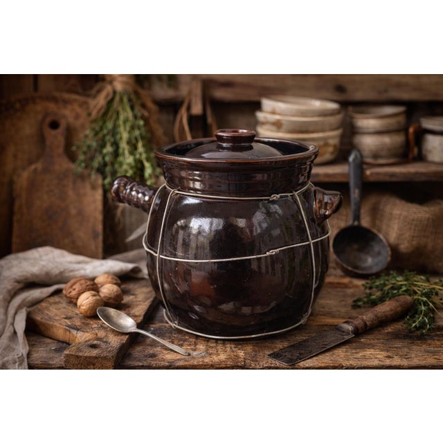 This is an authentic vintage stoneware bean pot featuring a rich dark brown glaze with subtle reddish undertones, complete...