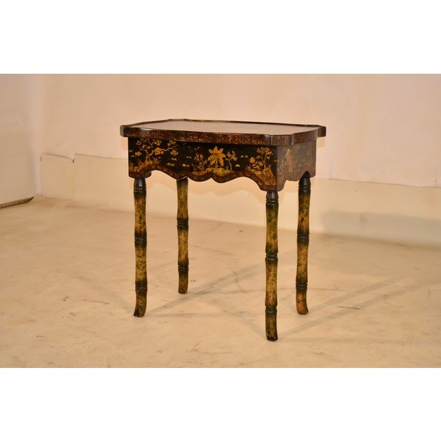 Circa 1960's hand painted side table with chinoiserie style decoration from England. The top of the table is shaped, and...