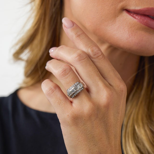 This elegant vintage diamond ring is a beautifully distinctive 1980’s design, featuring 22 carré and round brilliant cut...