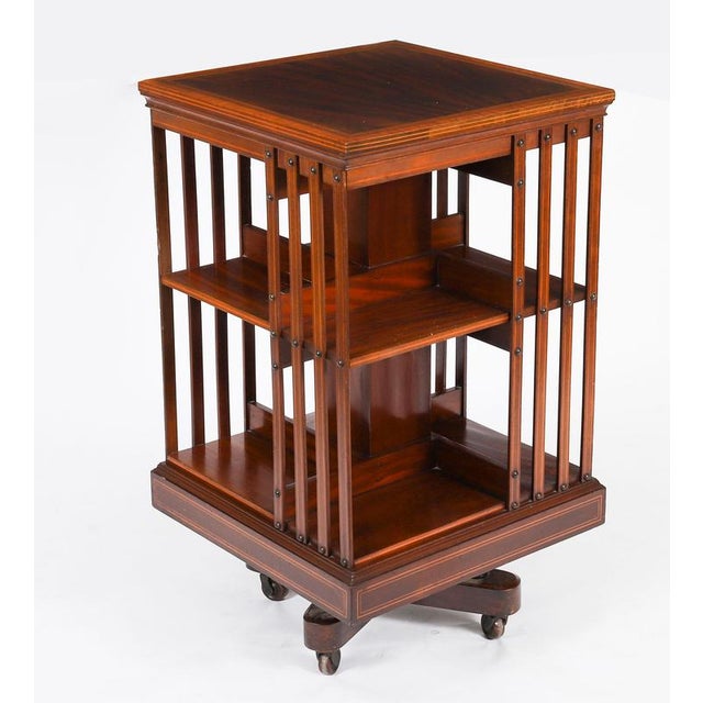 This is an exquisite antique Edwardian inlaid flame mahogany revolving bookcase, circa 1900 in date. It revolves on a...