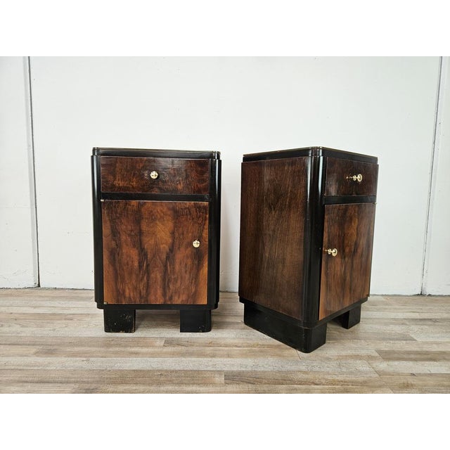 An elegant pair of original Art Deco bedside tables from the 1940s, crafted from fine walnut burl and featuring soft lines...