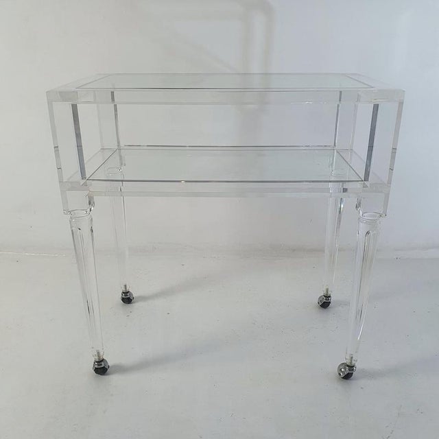 A two tiered bar cart in in acrylic glass with shelves in glass. In very good condition and very stabile. It also is easy...