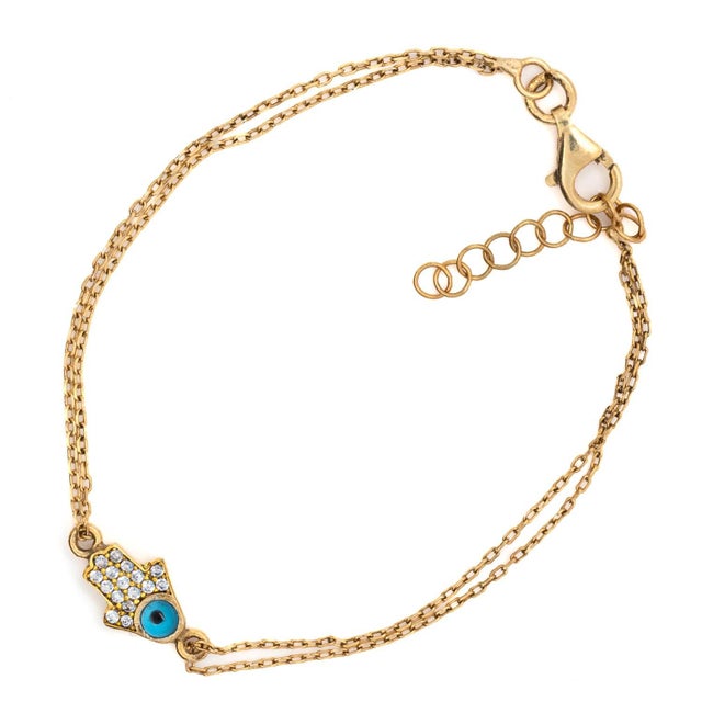 Minimalist Sparkly Hamsa Hand & Evil Eye Gold Bracelet is a delicate and meaningful adornment designed to bring a touch of...