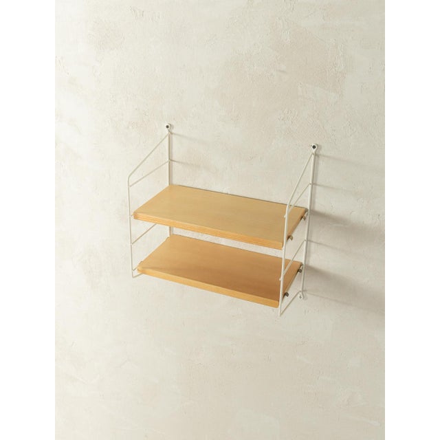 Original String shelving unit designed in 1949 by Nils Strinning in ash veneer. The system consists of two white metal...