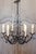 A French wrought iron chandelier from the 20th century with six lights and scrolling motifs, professionally rewired for...