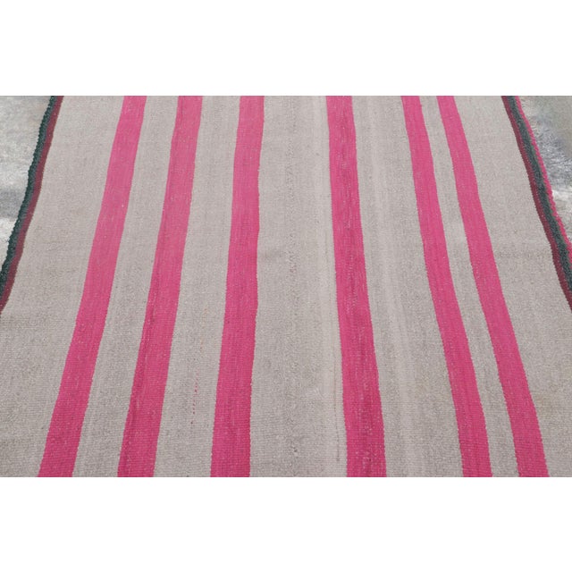 Handwoven in wool circa 1950–1960, this 5x6 vintage Kilim, woven in the tradition of a Frazada textile, is a striking...