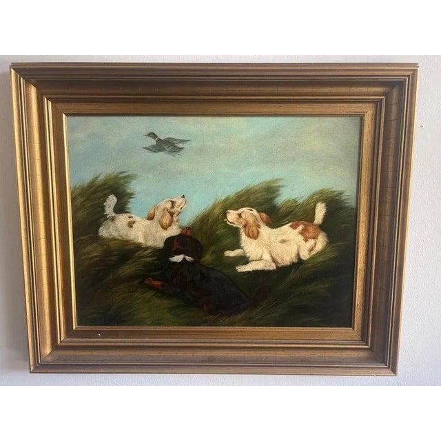 Charming English oil on canvas depicting three Spaniels and a flying duck overhead. Signed P. Hargrove. Original gilt frame.